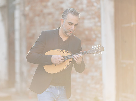 Close up portrait of Jacob Reuben with an acoustic mandolin