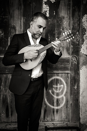 B&W shot of a musician sitting on stone steps