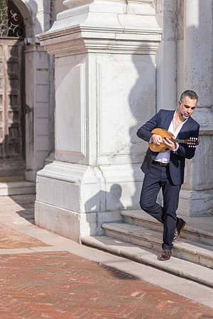 Musician posing by historical architecture