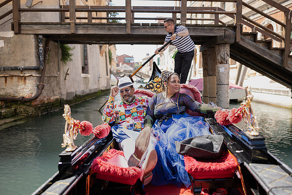 Couple whispering on a gondola ride in Venice.