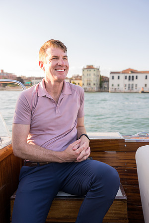 Father enjoying a peaceful water taxi ride in Venice with historic views