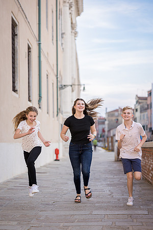 Family exploring hidden canals in Venice on foot during a family photo session