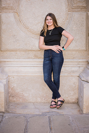 Daughter posing by a stone wall in Venice during a family photo session