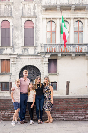 Parents and children posing in front of a historic Venetian building during a family vacation