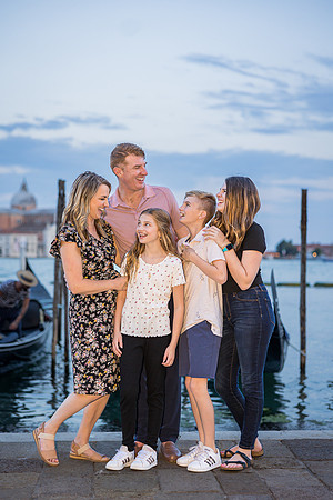 Family enjoying the beauty of a Venetian pier at sunset during their family vacation