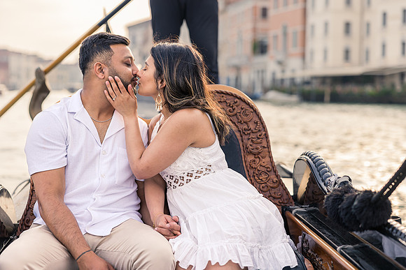 Couple laughing together on a romantic gondola ride in Venice.