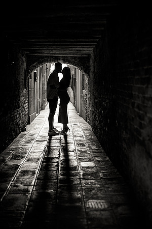 A couple shares a heartfelt kiss after a surprise proposal in Venice.