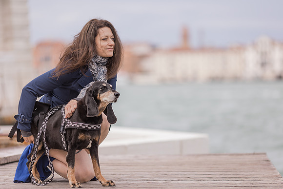Woman cuddling with her dog by Venice pier.