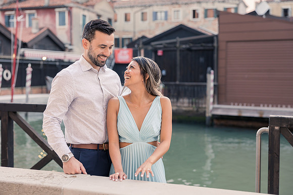 Engaged couple walking through Venice