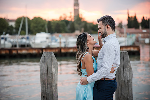 Engaged couple walking by the water in Venice