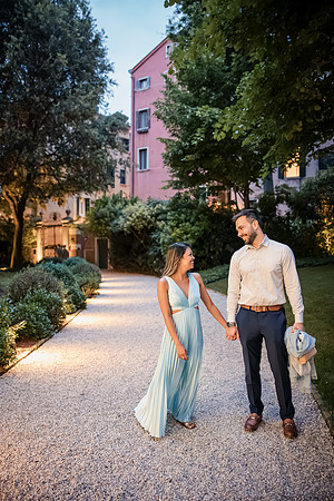 Engaged couple walking through a garden in Venice