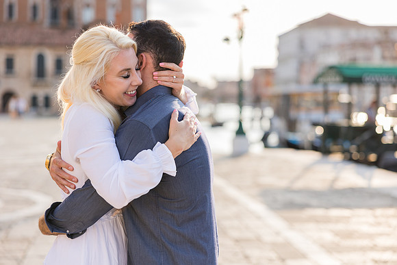 Couple gazing out at the Venetian lagoon after proposal.