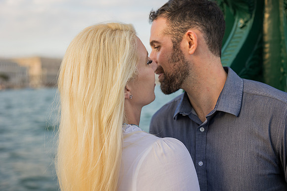 Stylish couple posing in Venice after surprise proposal.