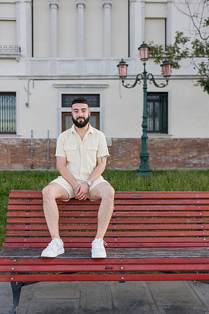 Man sitting on a bench in Venice, awaiting his fiancé.