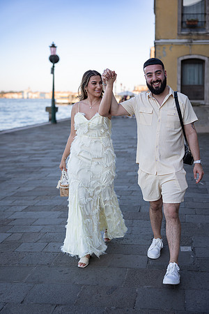 Couple walking along the canal in Venice at sunset.