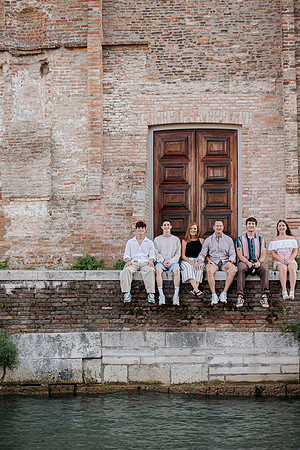 Family sitting by the water’s edge in Venice’s Cannaregio district
