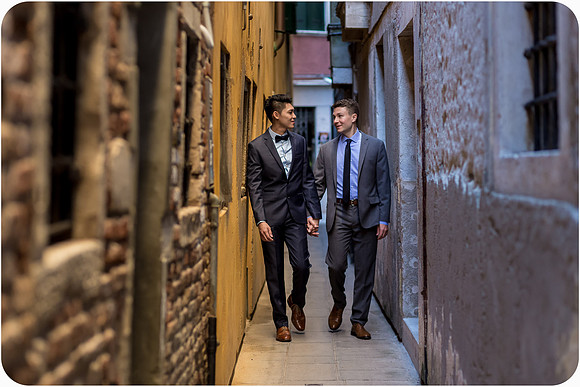 Engaged couple walking through a historic Venetian alley.