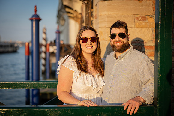 Parents posing by a canal in Venice during summer vacation.