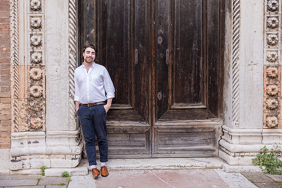 Brother leaning on a bridge in Venice during summer vacation.
