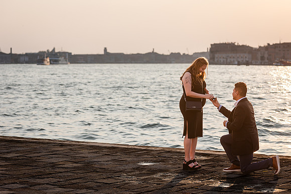 Man proposing at Venice waterfront during sunset