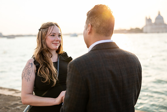 Couple smiling by Venetian waters after proposal