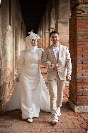 Couple walking in a historic alley in Venice, smiling.