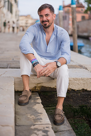 Man resting by the canal in Venice.