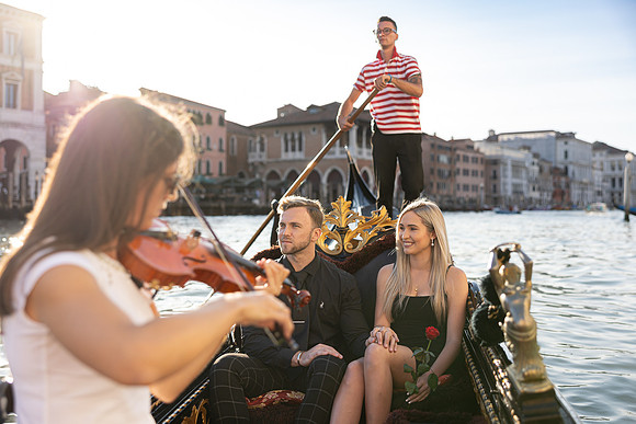 Couple in gondola with violinist in Venice