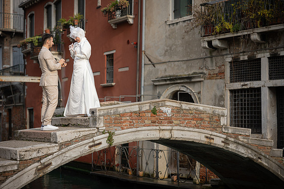 Couple holding hands while walking across Ponte Chiodo.