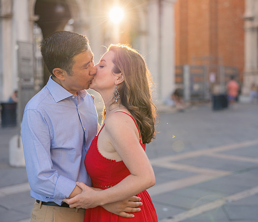 Parents kissing at sunset in Venice, framed by warm golden light during the family photo session.