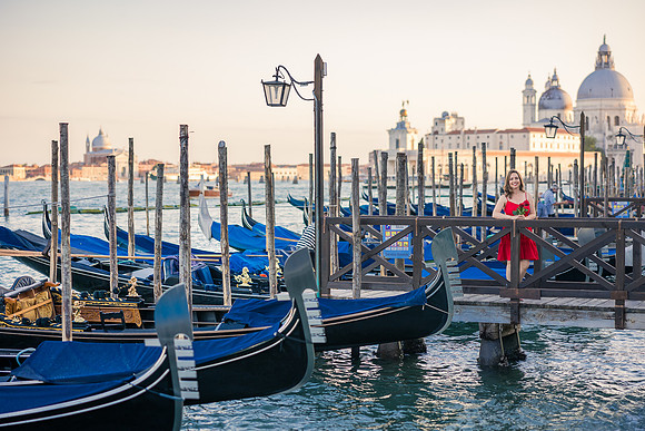 Family standing by the gondolas in St. Mark's Basin, enjoying a beautiful view of the Venetian lagoon.