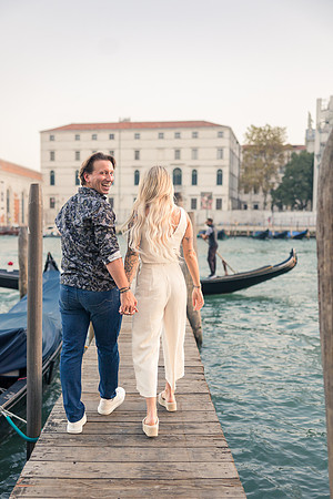 Couple strolling on dock as newly engaged in Venice