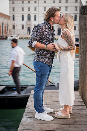 Kiss against Venetian architecture after proposal