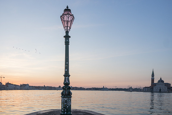 Venetian lamp post at dawn with lagoon view
