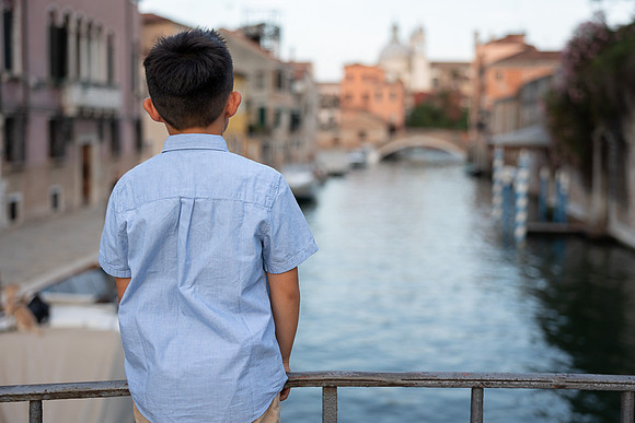 Child admiring the Venice canals during family vacation
