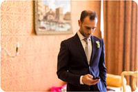 Groom adjusting his suit, preparing for his wedding in Venice.