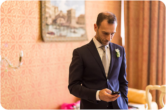 Groom adjusting his suit, preparing for his wedding in Venice.