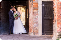 Bride and groom by a rustic door in Venice after their wedding ceremony.