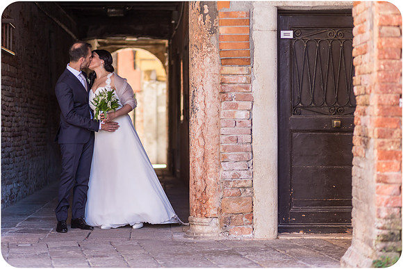 Bride and groom by a rustic door in Venice after their wedding ceremony.