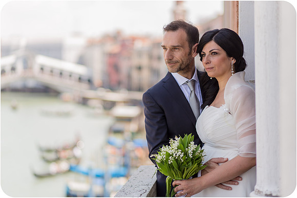 Bride and groom by the canal in Venice, sharing a peaceful moment after their wedding.