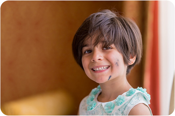 Smiling young girl in a blue dress during a Venice wedding.