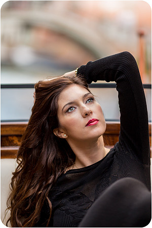 Elegant woman in a black dress on a luxury water taxi in Venice.