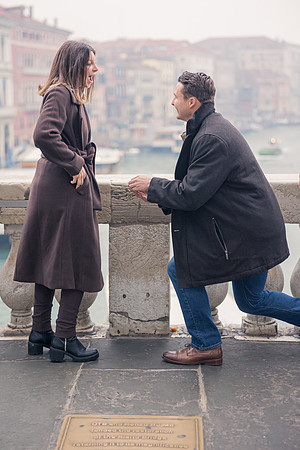 Man proposing to his partner on Rialto Bridge at sunrise.