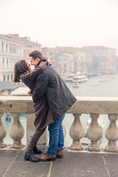 Couple standing by the Grand Canal, hugging after an engagement.