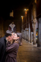 Couple kissing in a dimly lit Venetian street at sunrise.