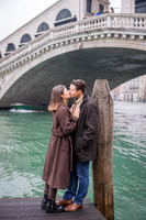 Couple embracing near the Rialto Bridge, enjoying their engagement moment.
