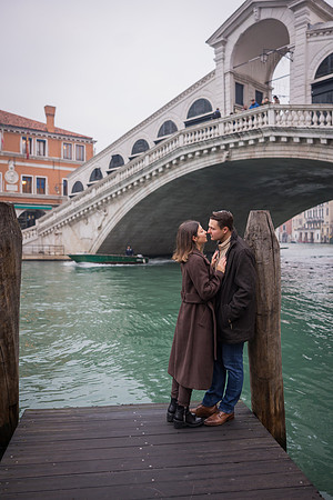 Couple kissing near the water in Venice after their proposal.