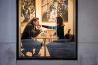 Couple raising their coffee cups in celebration at a Venice café.