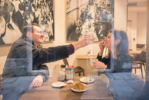 Couple enjoying breakfast in a Venetian café, laughing together.