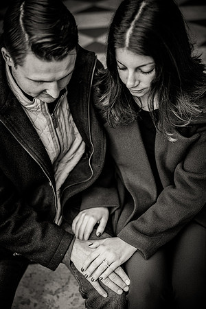 Couple holding hands, engagement ring in focus, celebrating love.